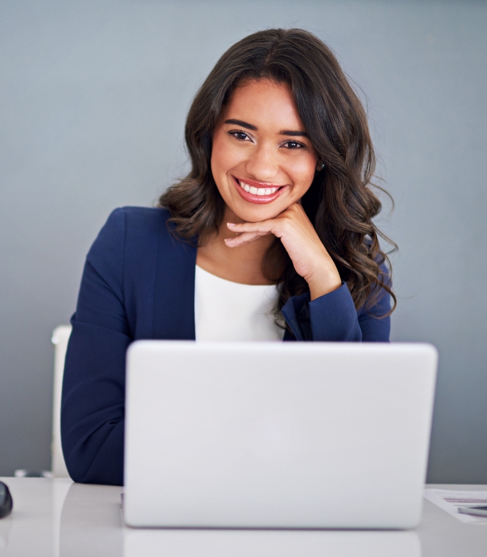 Smiling woman sitting in front of her laptop
