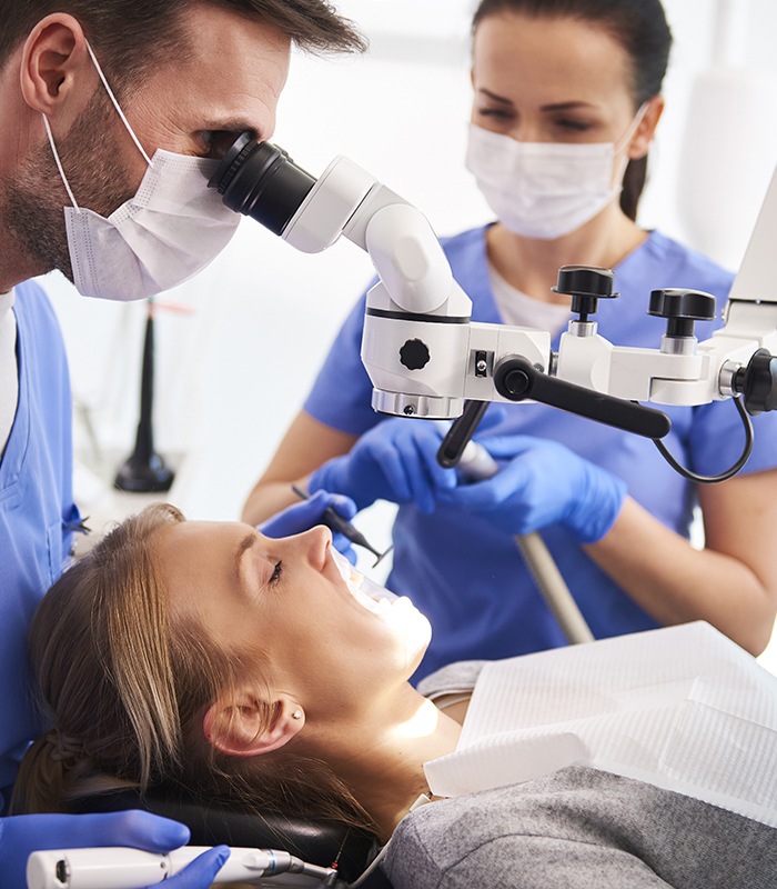 Dentist examining patient using dental microscope