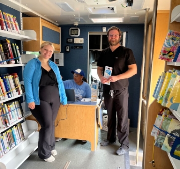 People standing and smiling in library