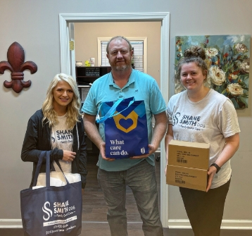 Dental team standing and holding bags and boxes