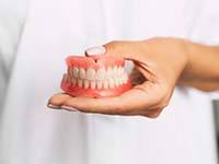 dentist holding a set of full dentures