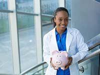 smiling dentist holding a piggy bank