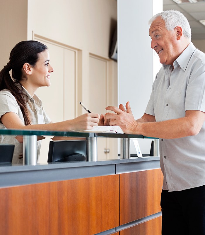 Man discussing the cost of treating dental emergencies with dental team member