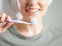 a person holding up a toothbrush