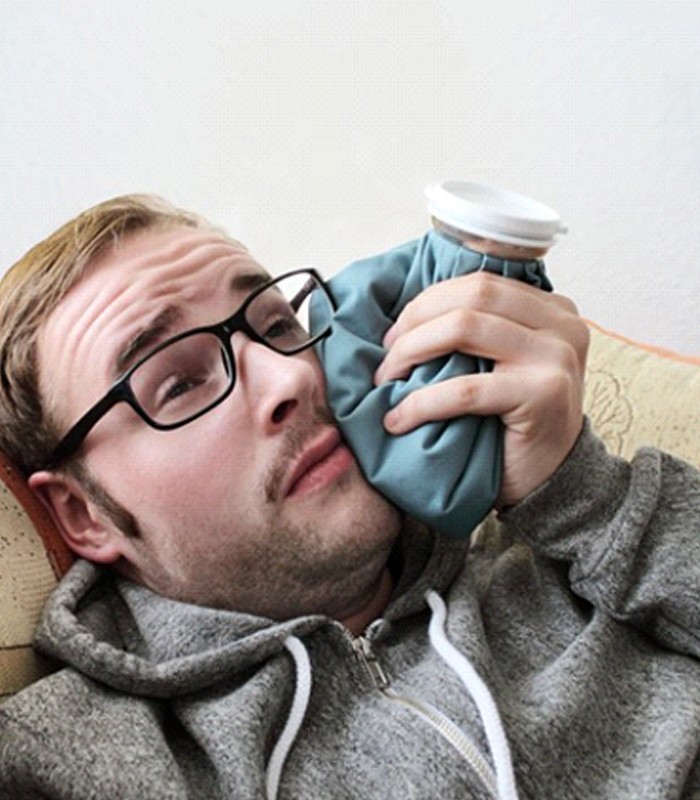 man holding an ice pack to his cheek