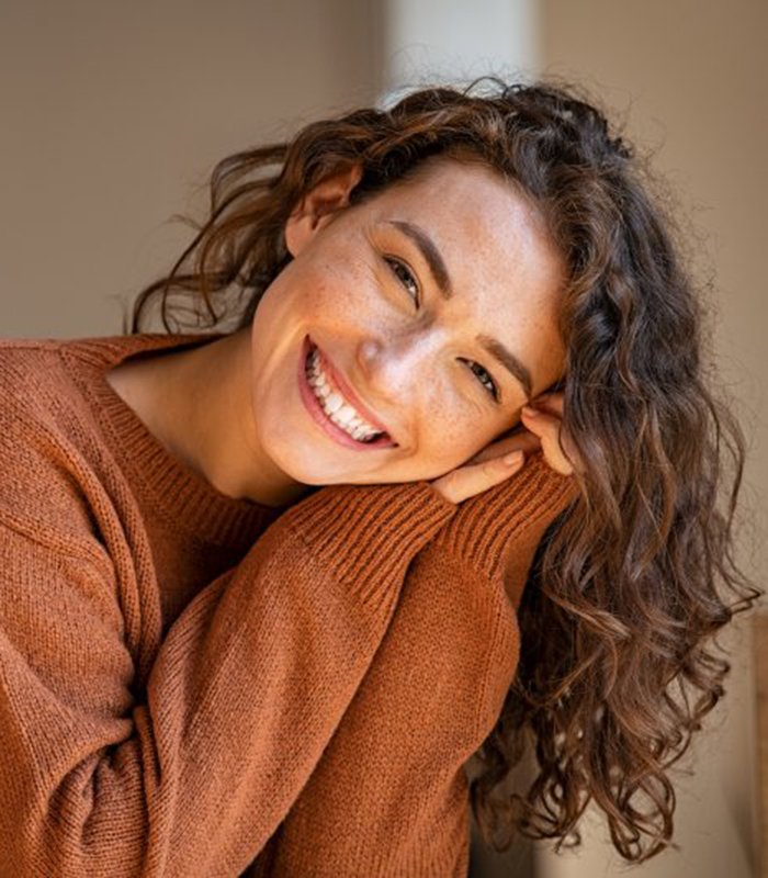 a woman smiling after receiving tooth colored fillings