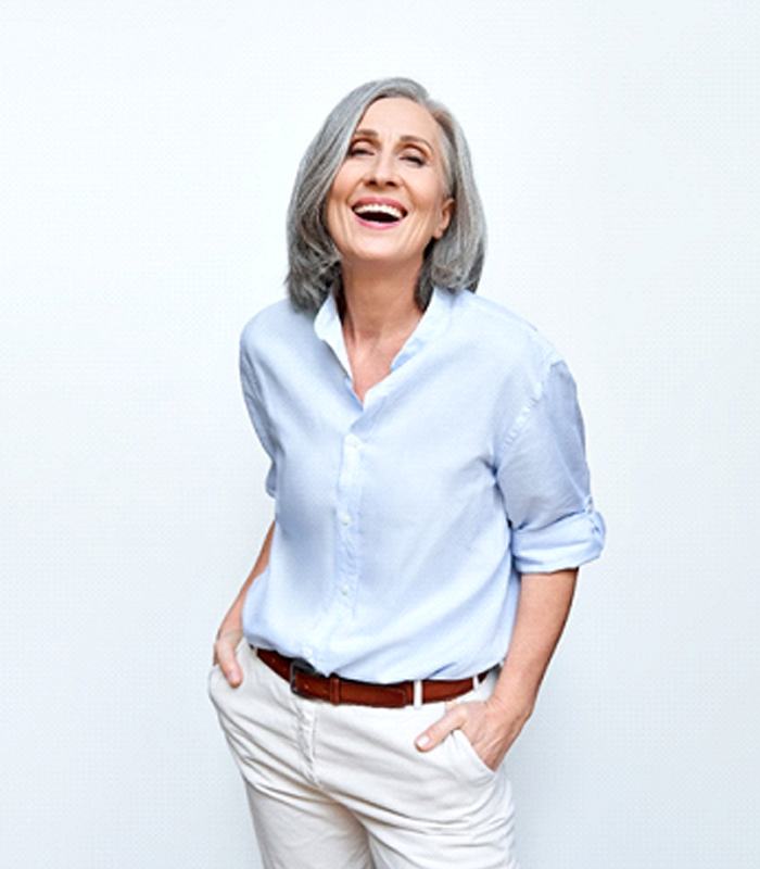 Happy senior woman enjoying the benefits of implant dentures