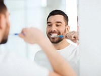 man brushing his teeth 