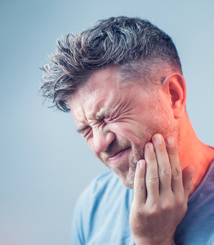 Man with toothache, concerned about dental implant failure