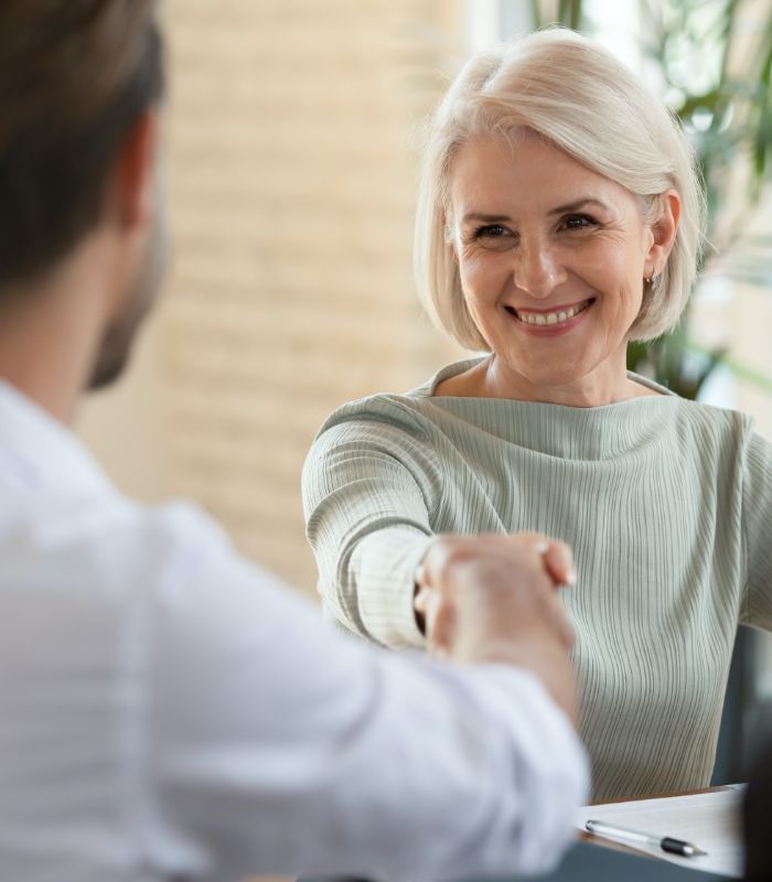 Woman discussing cost of tooth replacement with dental implants