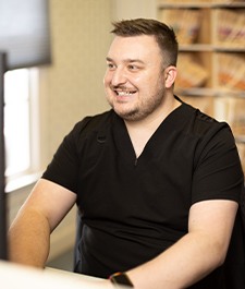 Jonesboro dental team member smiling and sitting at desk