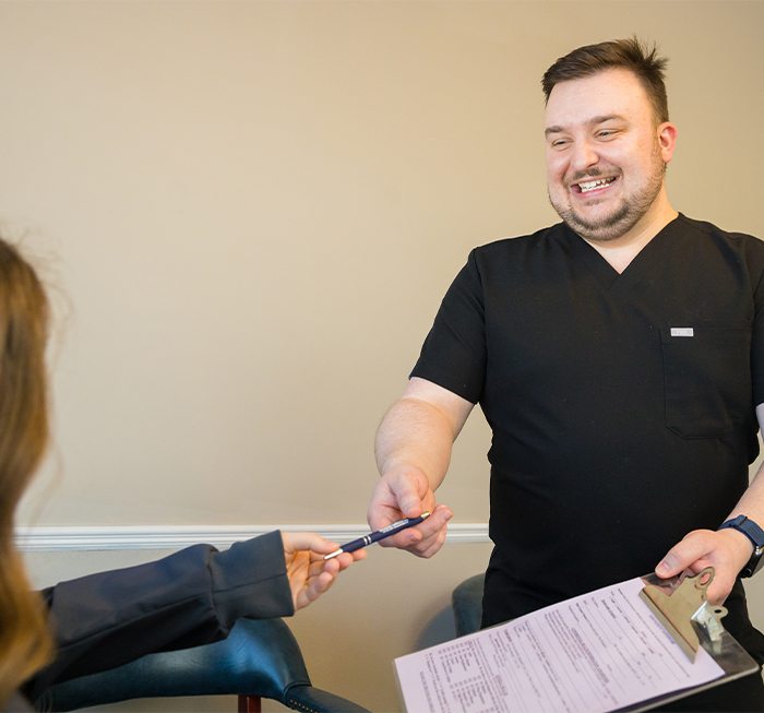 Dental team member and patient reviewing dental insurance forms