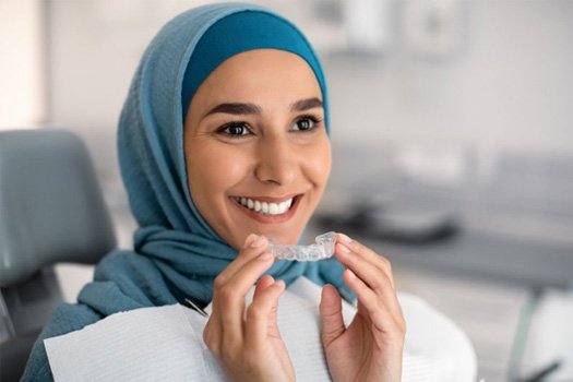 Patient in Brookland holding SureSmile clear aligners