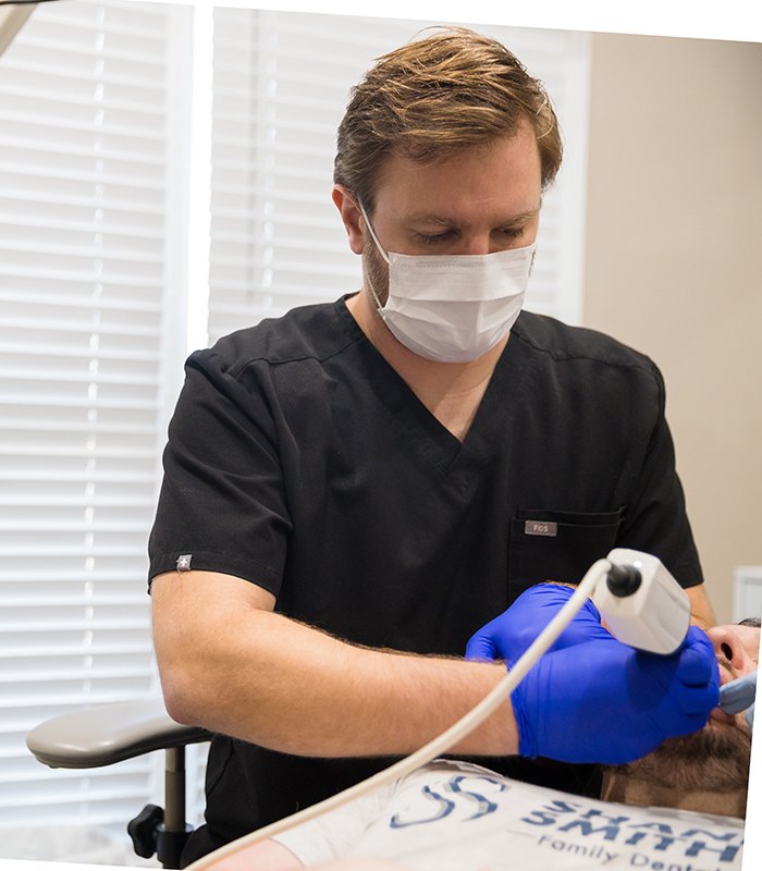 Dentist examining smile after tooth colored filling restorative dentistry treatment