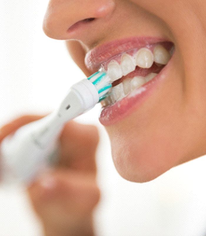 Woman brushing her teeth to maintain teeth whitening in Jonesboro