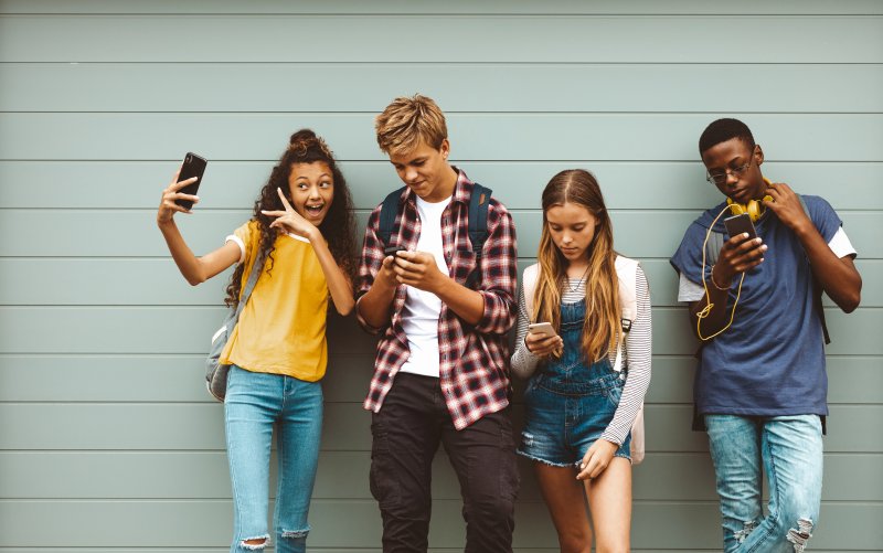teenagers looking at their phones in Jonesboro