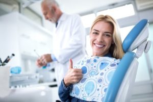 Woman giving a thumb’s up at the dentist’s office.