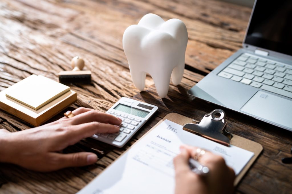 Patient filling out dental insurance paperwork at desk