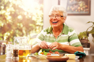 Senior woman laughing while enjoying a meal