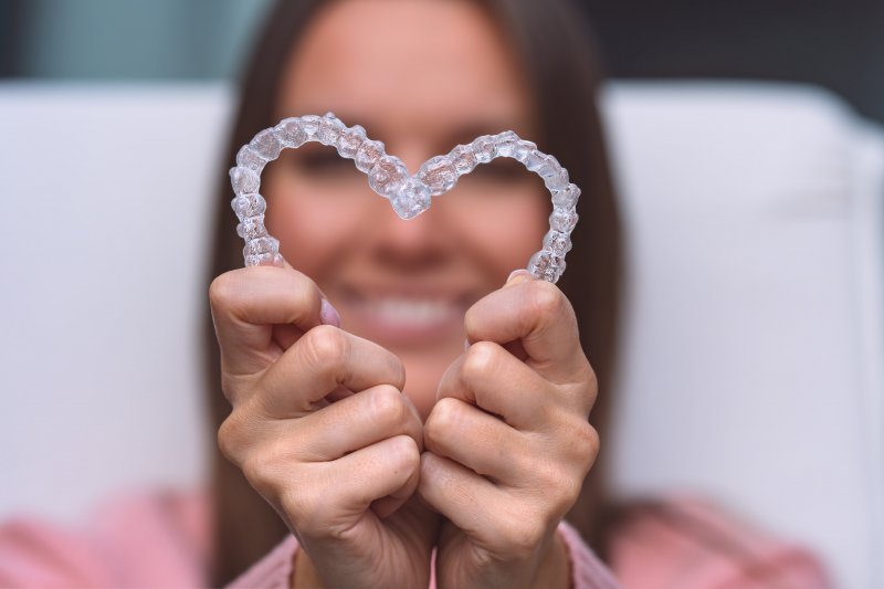 woman holding clear aligners