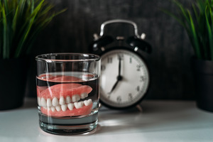 denture sitting next to a clock