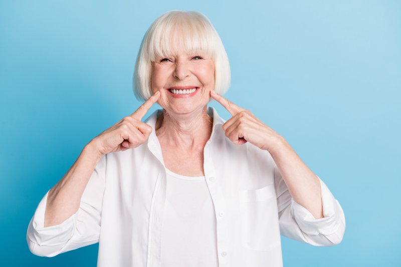 An older woman smiling with her new dental implant dentures