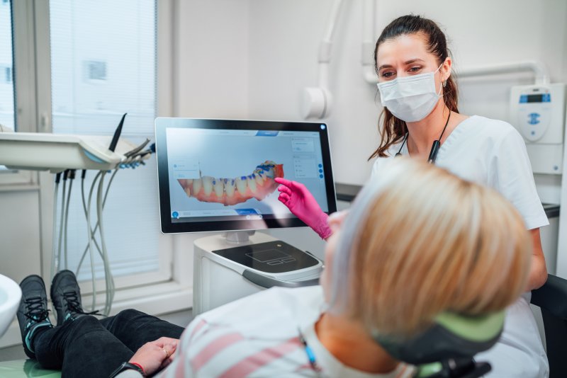 A dentist using an intraoral scanner on a patient