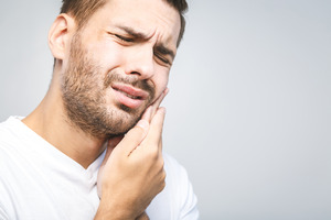 Man with toothache rubbing his jaw
